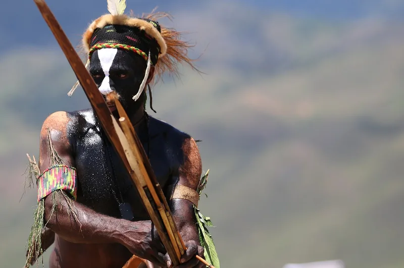 Painted warrior with a bow at the Baliem Valley Festival