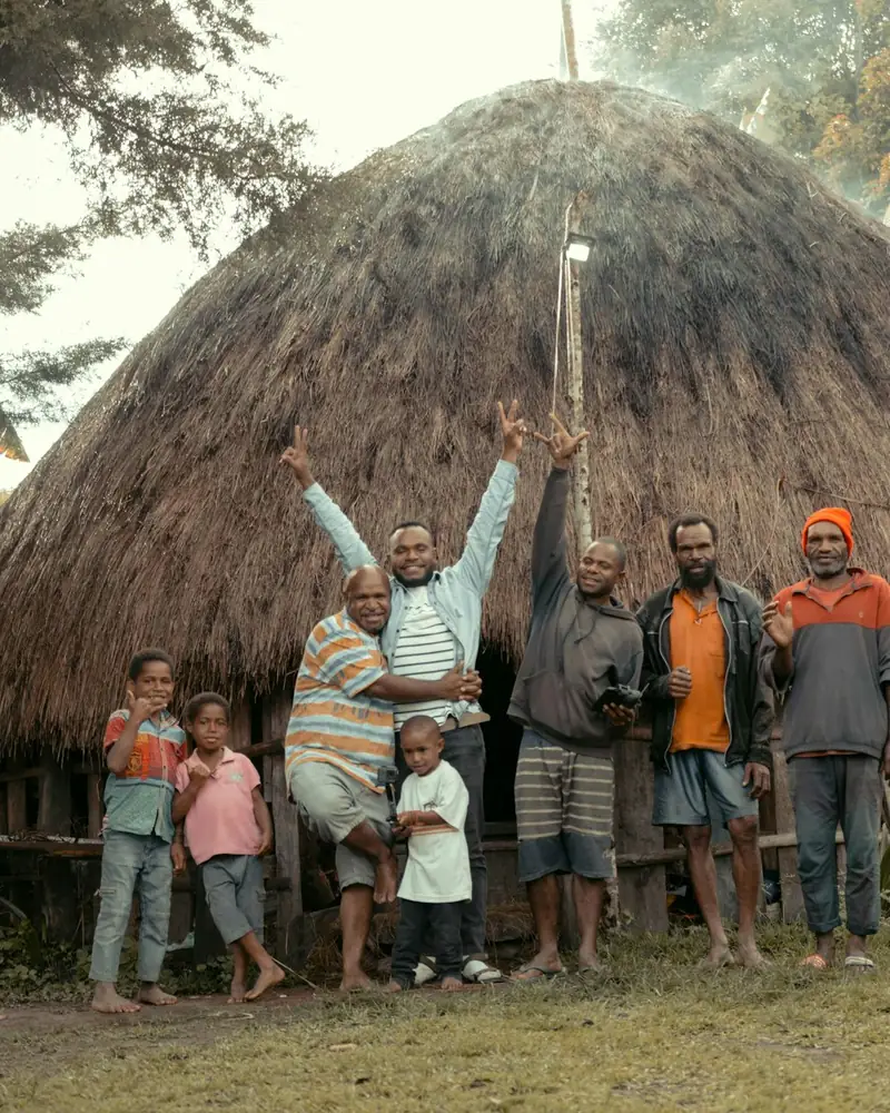Dani family in front of a honai near Wamena